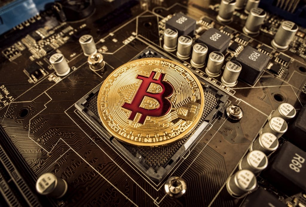Gold Bit Coin BTC coins on the motherboard. Bitcoin is a worldwi