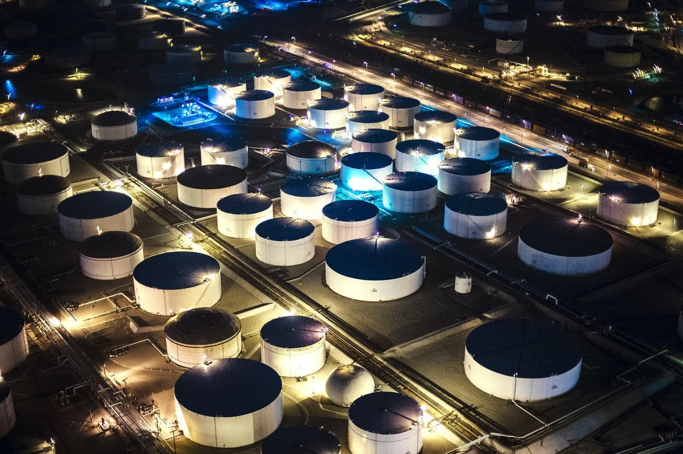 Aerial view of oil refinery storage tanks illuminated at night, Los Angeles, California, USA