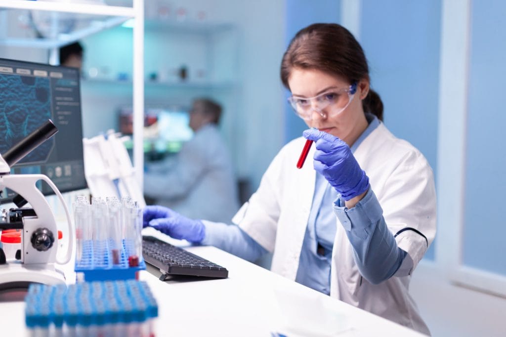 Biotechnologist woman scientist researching with a blood tube in pharma lab