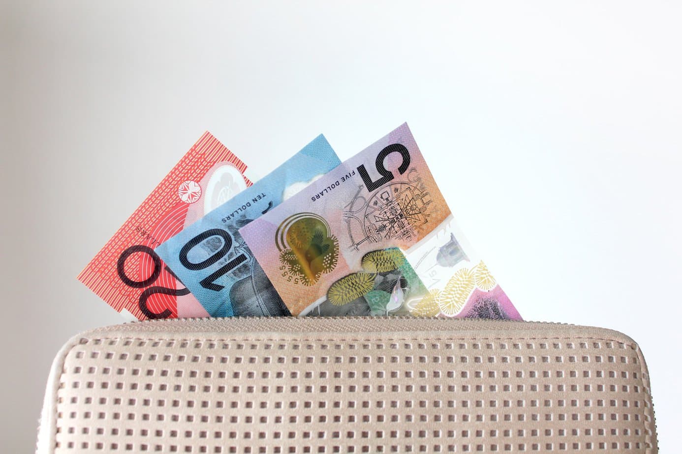 Australian dollar bills sticking out of a ladies purse or wallet, spending money, cash, AUD